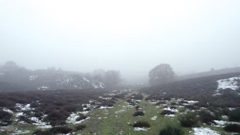 Tief-Fliegende-Luftaufnahme-Zeigt-Moorlandschaft-Mit-Schnee-Und-Dichtem-Nebel-Winterszene-In-Holländischer-Hügellandschaft