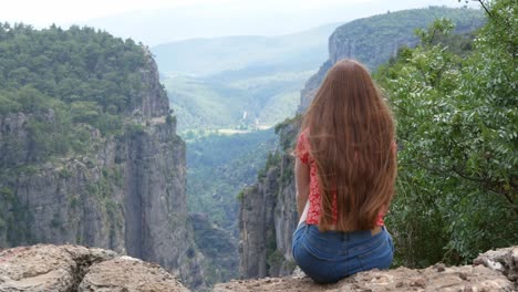red hair woman makes photo of tazi canyon in turkey