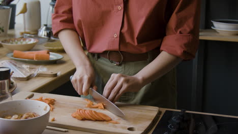 woman chopping carrots in a bright kitchen