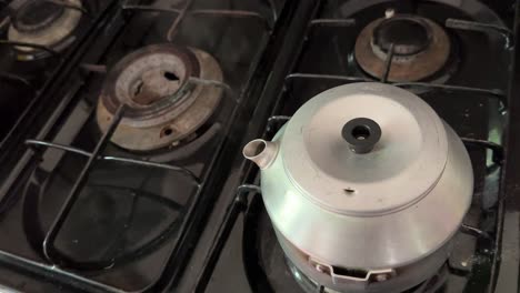 old camping boiling kettle with steam texture on a dirty stove in caucasian home in forest to make herbal tea and home made coffee ethiopia hot drink brew concept and brunch gathering in iran