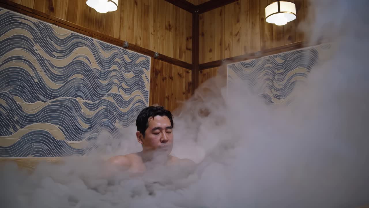 Una scena video serena cattura un uomo che si rilassa in un bagno di vapore, ripreso da un angolo frontale, con elementi in legno