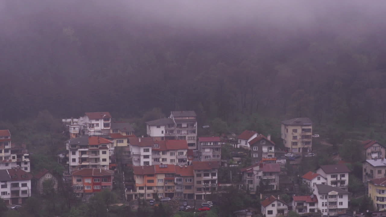 깊은 안개가 마을을 덮고 있는 동안 불가리아의 vratsa 마을과 주변 산 stara planina의 4k 영상