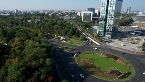 vista giratoria del avión no tripulado sobre la casa de la plaza de la prensa libre en bucarest, rumania, con el imponente edificio casa presei en el fondo, rodeado de vegetación exuberante y altos edificios de oficinas