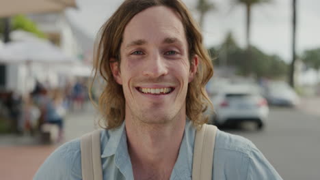 retrato de un joven caucásico feliz riendo disfrutando de un estilo de vida de vacaciones independiente un atractivo turista masculino en una soleada calle urbana frente a la playa en cámara lenta