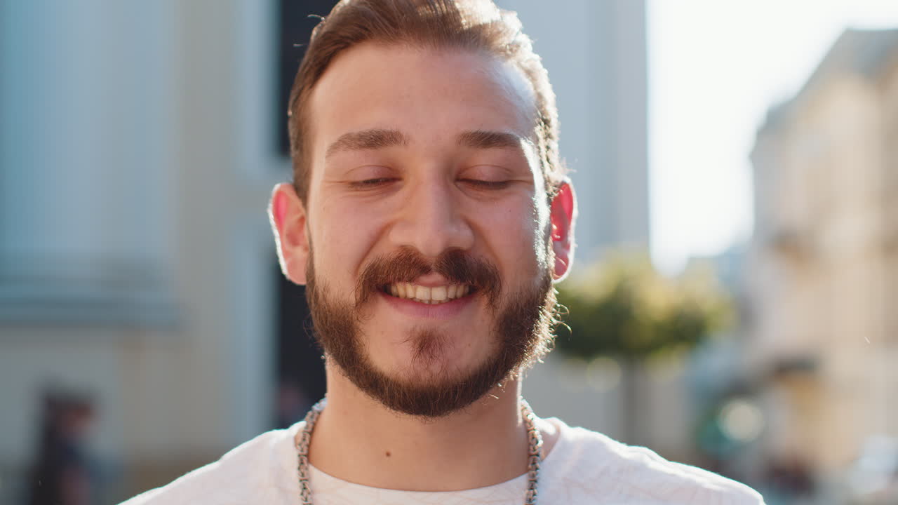 Happy young man smiling looking away dreaming resting good news feel satisfied in city street