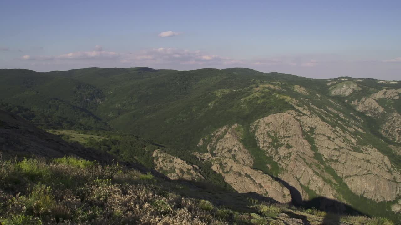 Pan shot on Stara planina and Sliven Valley. Tall mountains and green hills are shown from a high viewpoint. The view reveals valleys and distant horizons. The Balkan Mountains above Sliven town