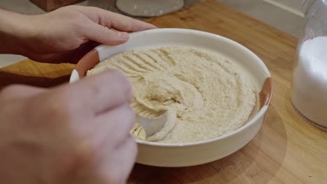 chef decorates freshly made hummus plate