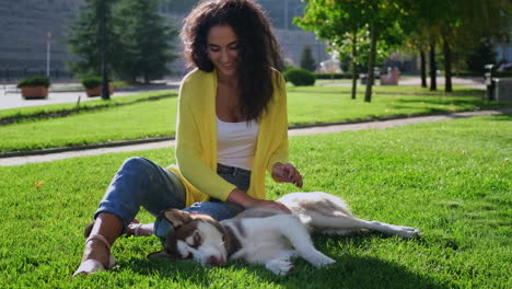 woman playing with her husky dog in a park