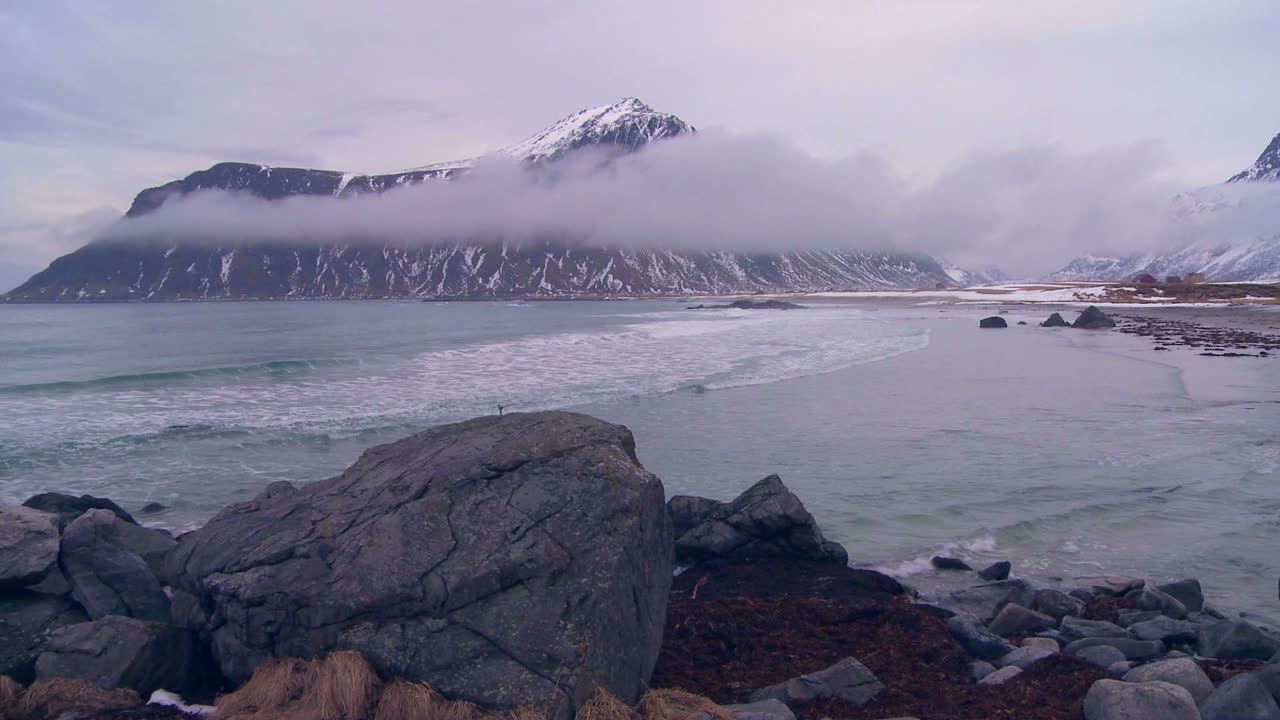 노르웨이 로포텐 섬의 북극권 북쪽 피요르드 가운데 아름다운 안개가 자욱한 눈 덮인 해안선
