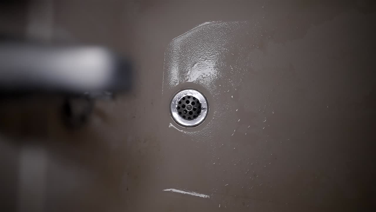 Close-up of Shower Drain and Wet Surface in Bathtub, Water Draining
