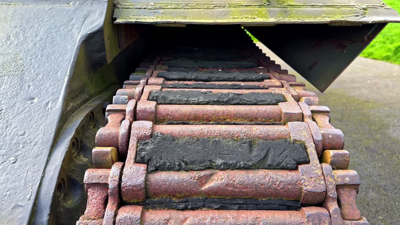 Close view of rusted tank track links and rubber pads on military vehicle at Overlord Museum, Normandy, France