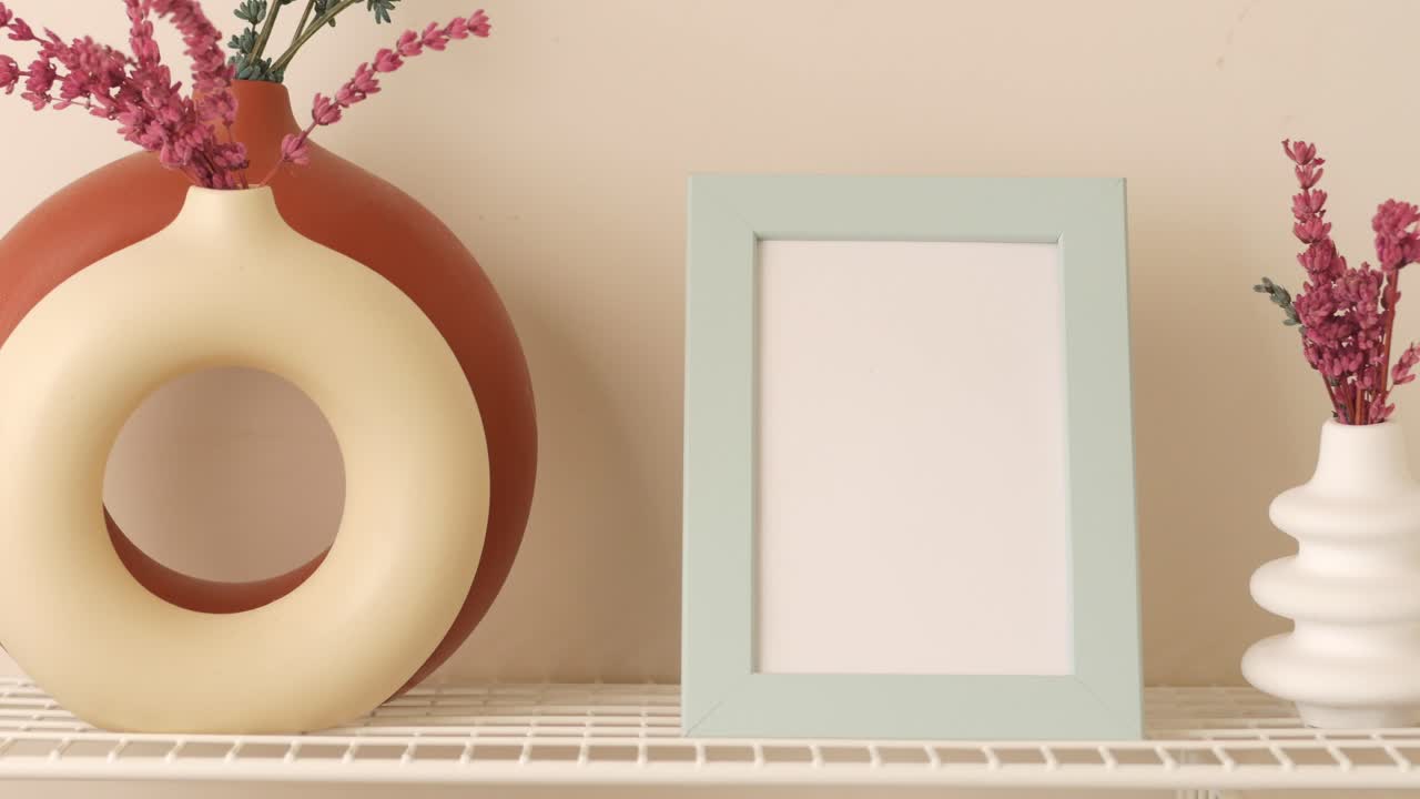 arreglo elegante de decoración del hogar con marco vacío y jarrones