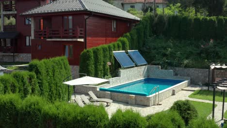 Beautiful-holiday-cabin-villa-and-swimming-pool-in-mountains,-rising-aerial-view