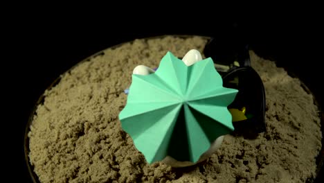 a white piggy bank stands on a sandy beach and revolves on a black background.