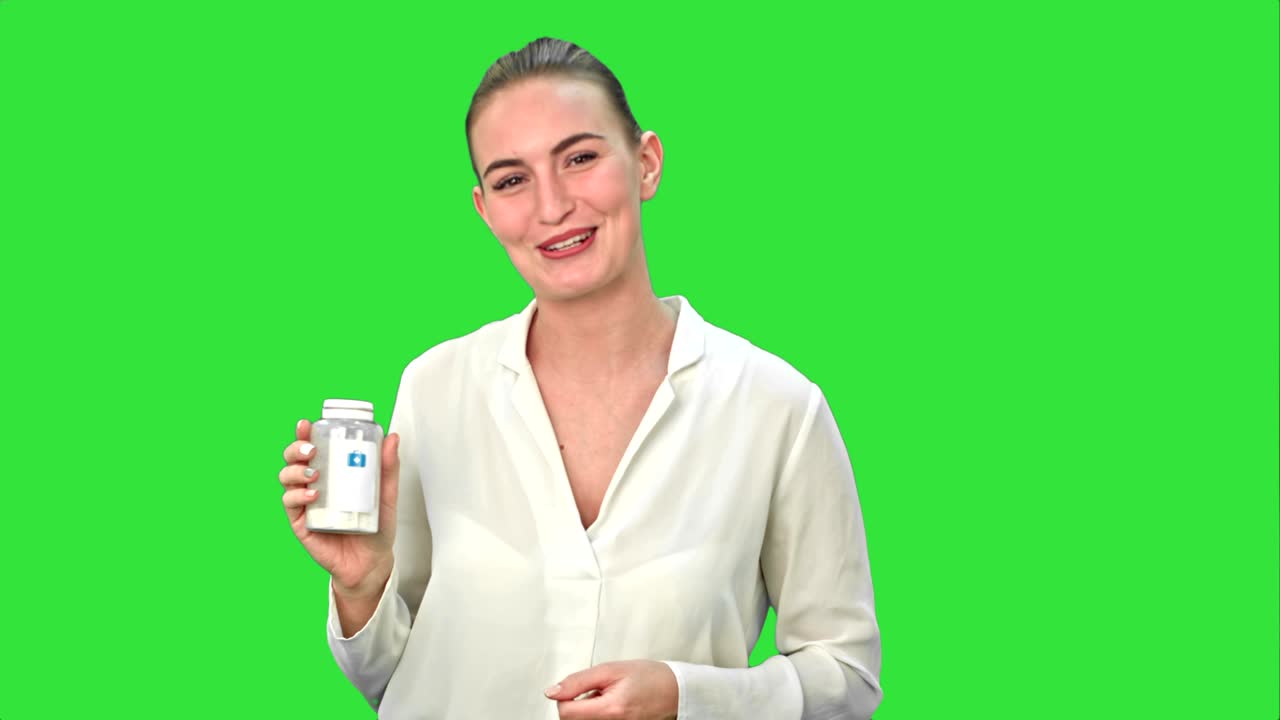 초록색 스크린, 크로마 키에서 카메라를 위해 약을 설명하고 광고하는 예쁜 여성