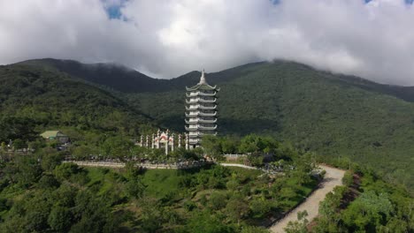 drone aéreo de la estatua alta de buda y la torre del templo con enormes montañas, impresionante costa y océano en da nang, vietnam