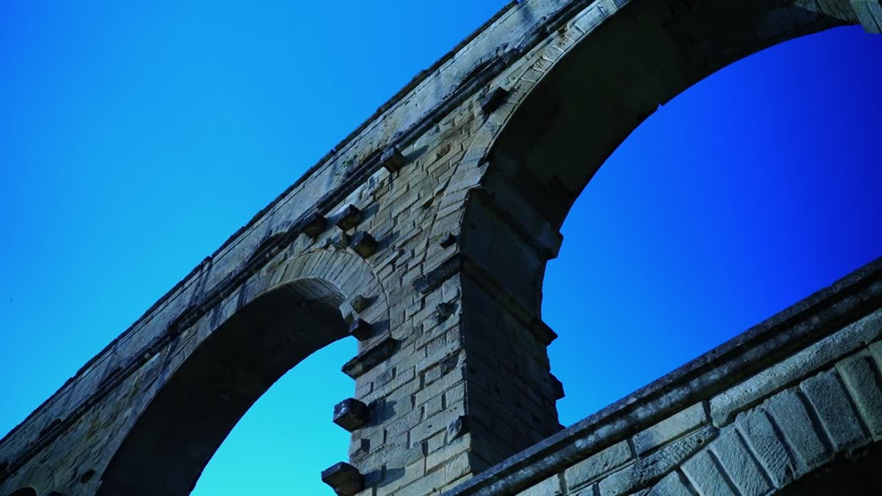 프랑스의 푸른 하늘 아래에 있는 로마의 물 파이프의 큰 돌 아치 pont du gard