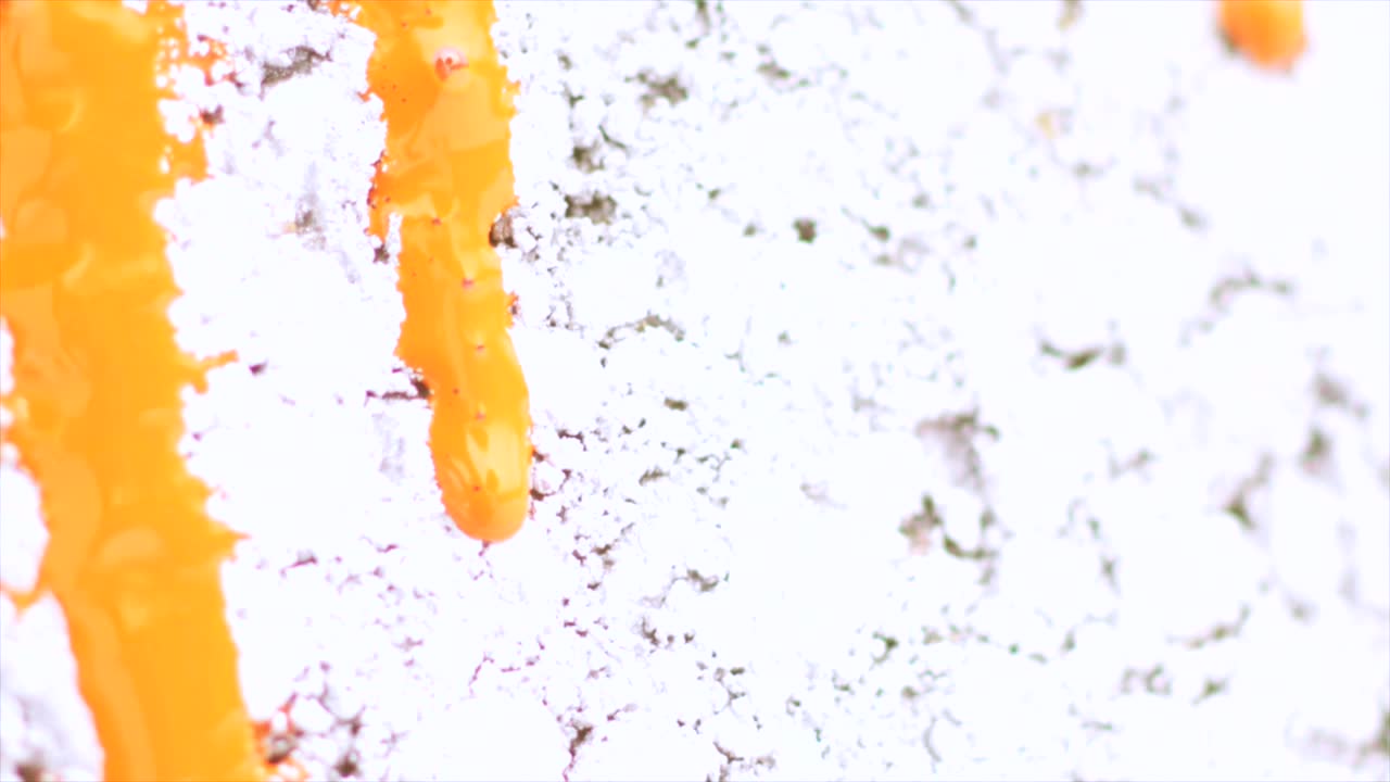 pintura naranja goteando en la superficie blanca