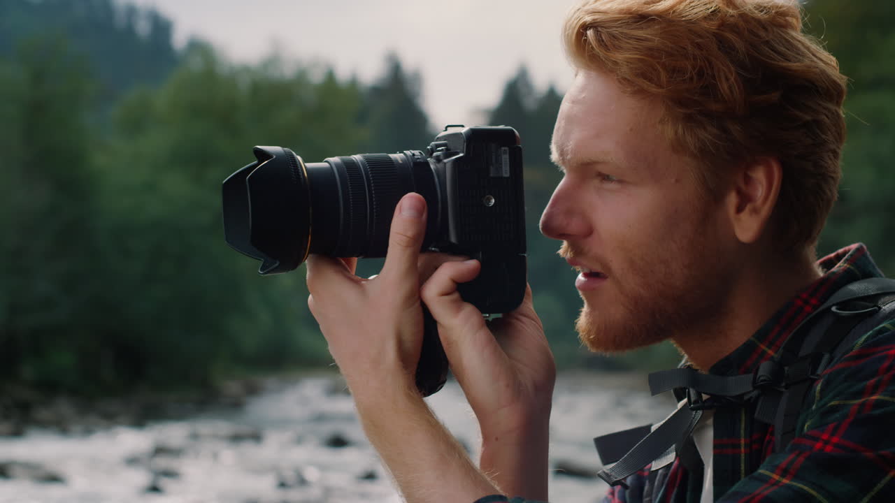 фотограф, использующий фотокамеру в горах