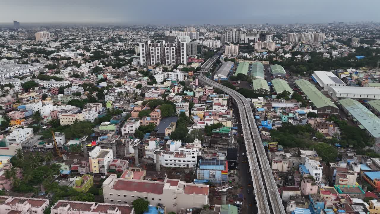 Filmati aerei catturano la trasformazione dinamica di Chennai sotto un cielo monsonico spettacolare. Nubi di pioggia scura incombono sulla città mentre la costruzione della metropolitana Fase 2 e un vasto magazzino CFS sono in funzione.