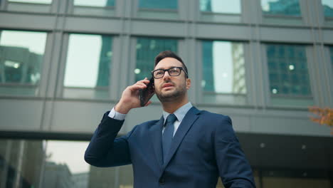 French-Businessman-Talking-On-Phone-Outside-Its-Office-Building-In-Seoul,-South-Korea