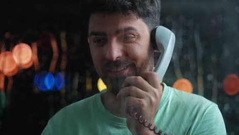 man talking on a retro phone with blurry lights in the background