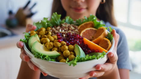 person holding a large bowl of healthy vegan salad