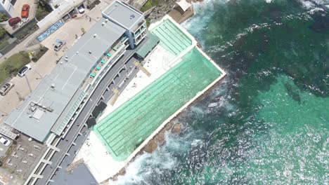 Blue-Ocean-Waves-Crashing-At-Oceanside-Pool-With-Tourists---Bondi-Beach-In-Sydney,-NSW,-Australia