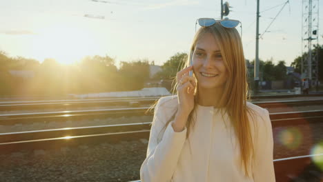 Portrait-Of-Successful-Business-Woman-On-A-Trip-He-Talks-On-The-Phone-At-The-Railway-Station