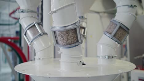 grain pouring through transparent inspection tubes at a state-of-the-art grain mill facility, showcasing large-scale food production on an industrial level