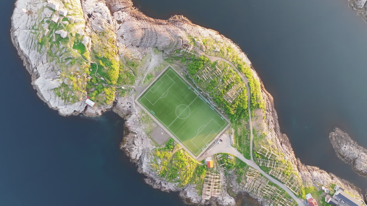 Fantastic aerial view descending over the famous Henningsvaer football field on the Lofoten Islands during sunset. Norway.