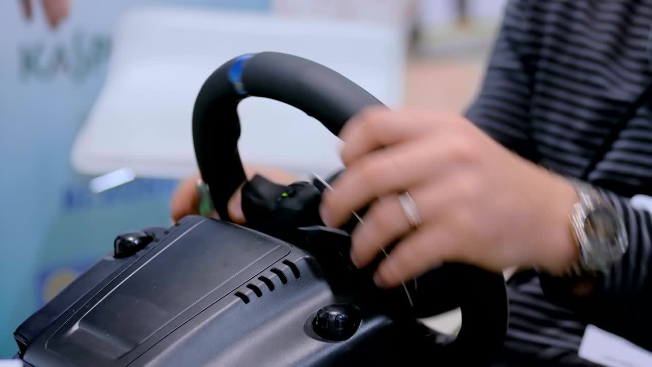 기술 전시회 에서 게임 스티어링  조이스틱 을 사용 하는 사람