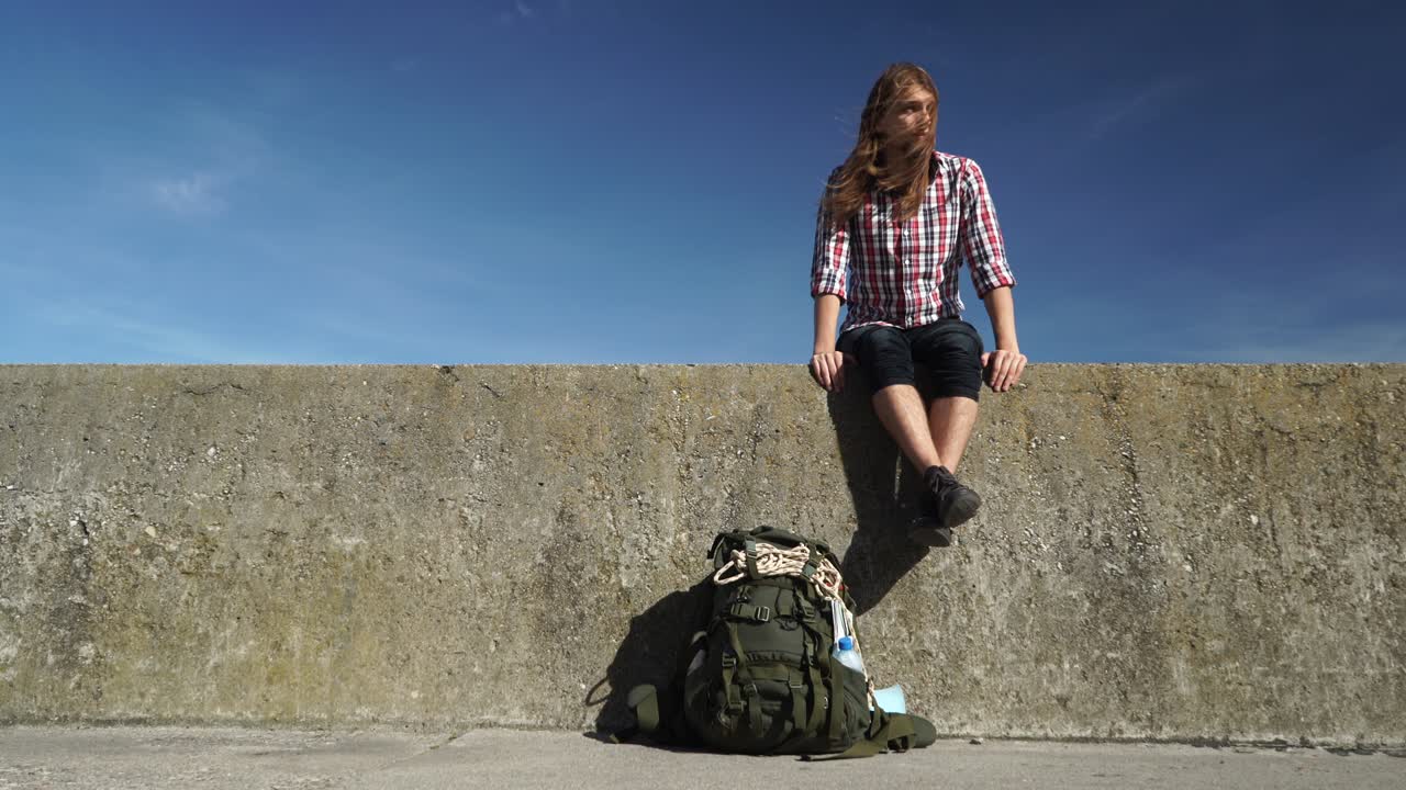 돌 벽에 앉아있는 관광 배 타는 남자 야외 4k