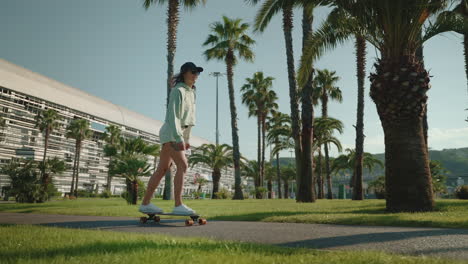 woman skateboarding in a palm tree park