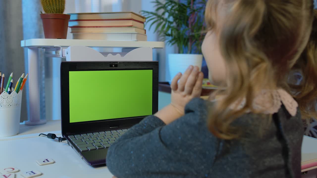 niña estudiando tareas educación a distancia en portátil cámara web lección en línea en casa, pantalla verde