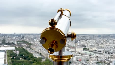 close-up of telescope on eiffel tower, view of the trocadero and other parisian landmarks on a cloudy parisian day from the eiffel tower