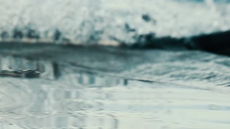 close up of a paddle being moved gently over the water surface, which splashes