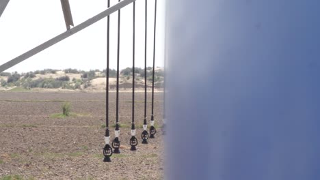 close up view of sprinkler pivot at work, watering crop for more growth