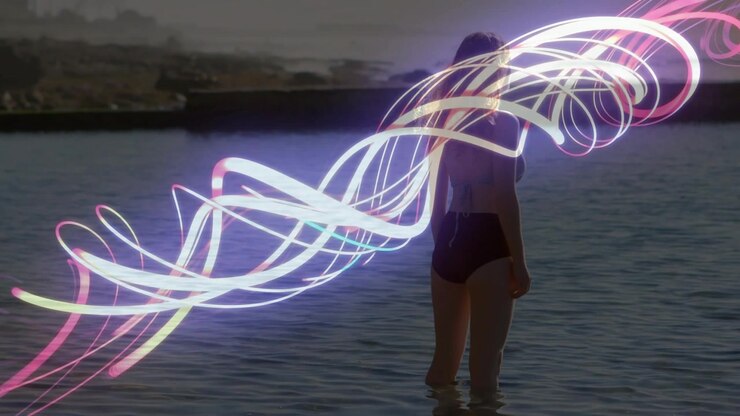 Woman wading in bay water, neon ribbon entering left and wrapping around torso for art