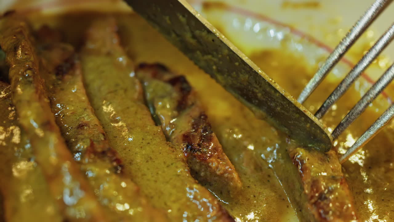 Close up of a plate of fries with meat and green sauce on a plate