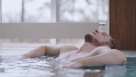 relax in wellness and spa center after work adult caucasian man is lying in warm water of pool