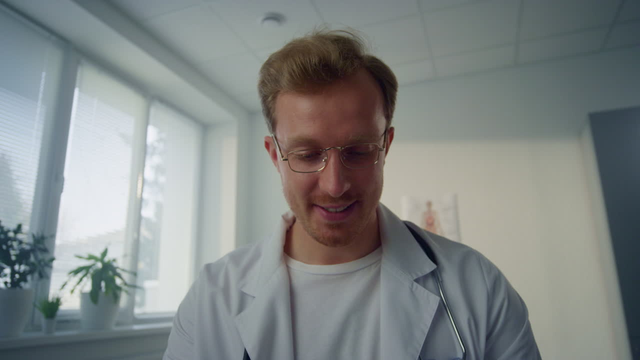 Arzt gibt medizinische Beratung in der Klinik, POV-Video. Porträt eines männlichen Arztes.