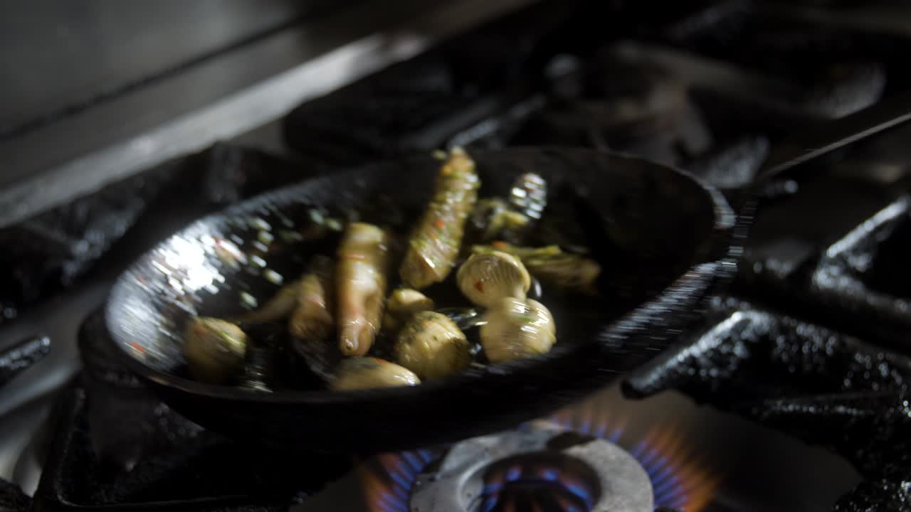 Chef mixes the ingredients inside of the pan, flips it over