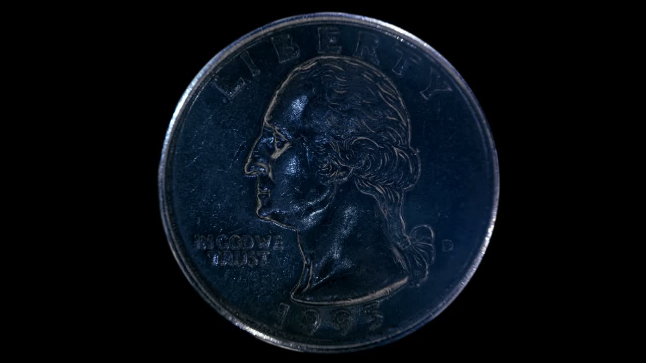 en un fondo negro, una moneda de un cuarto de dólar brillando en la luz cae en el agua