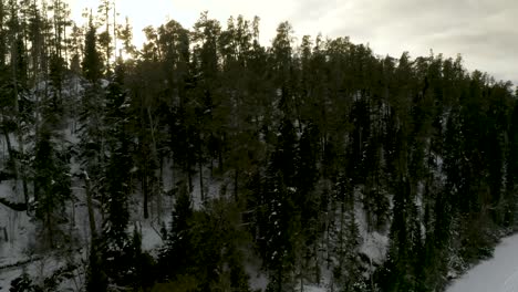 Aerial-pan-of-sun-setting-behind-the-winter-boreal-forest-in-northern-Canada