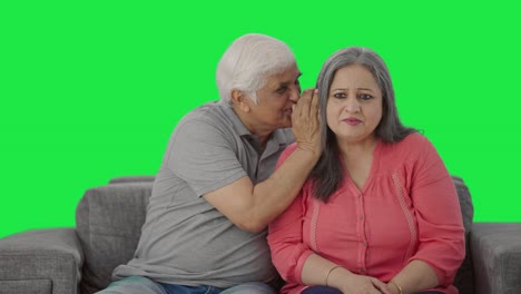 Happy-Indian-old-husband-telling-a-secret-to-his-wife-in-ear-Green-screen