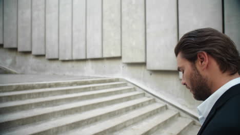 Business-man-working-with-documents-in-city.-Male-entrepreneur-walking-up-stairs