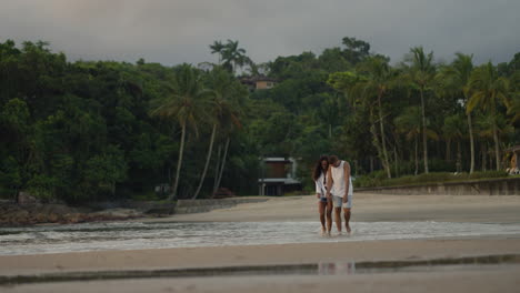 una pareja tomándose de la mano al atardecer.