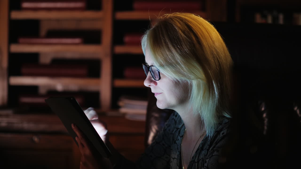 Blonde Woman Works on Tablet at Night