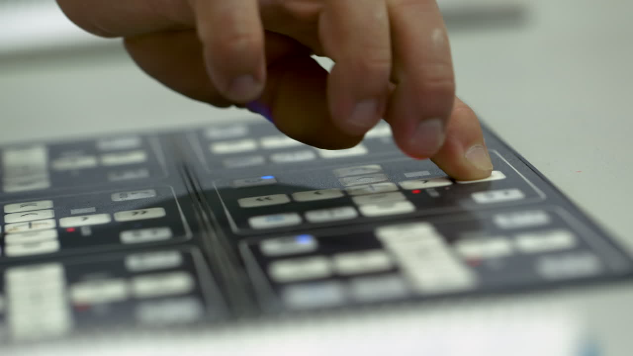Closeup of caucasian man's hand operating a machine panel